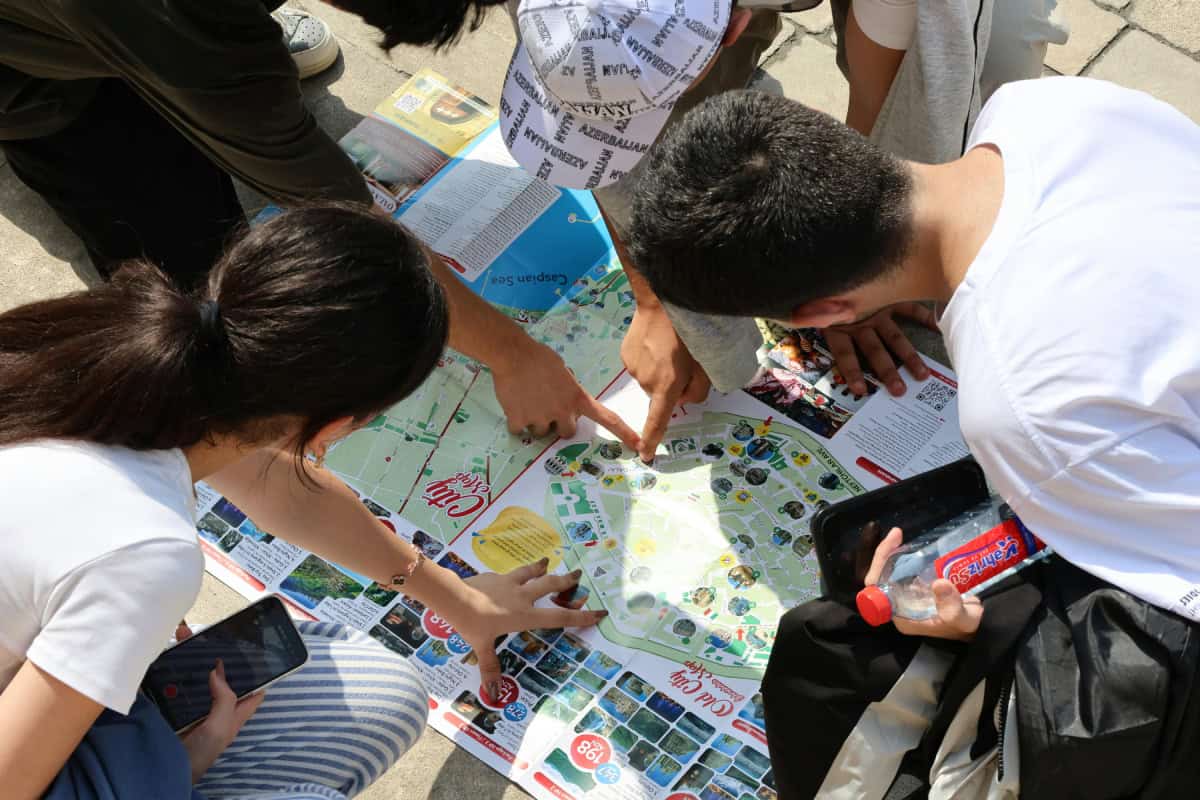 Travelers sitting together on holiday planning their trip with a map