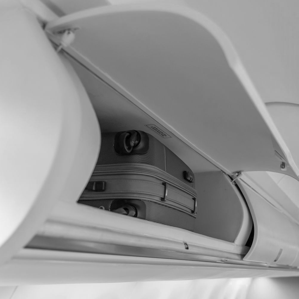 Photo of a suitcase placed inside an airplane overhead storage compartment